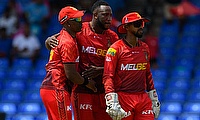 Dwayne Bravo (L), Andre Russell (C) and Nicholas Pooran (R) of Trinbago Knight Riders celebrates the dismissal of Faf Du Plessis