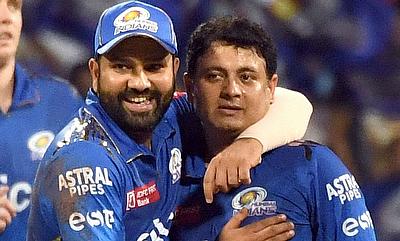 MI's Piyush Chawla with team captain Rohit Sharma celebrate the dismissal of RR's Jos Buttler