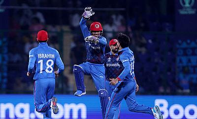 Afghanistan's Rashid Khan celebrates with teammates after bowling out India's Rohit Sharma alt=