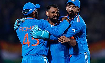 India's Mohammed Shami celebrates with Rohit Sharma after taking the wicket of New Zealand's Daryl Mitchell alt=