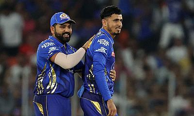 Mumbai Indians' Mujeeb Ur Rahman celebrates with Rohit Sharma after taking the wicket of Gujarat Titans' Jos Buttler alt=